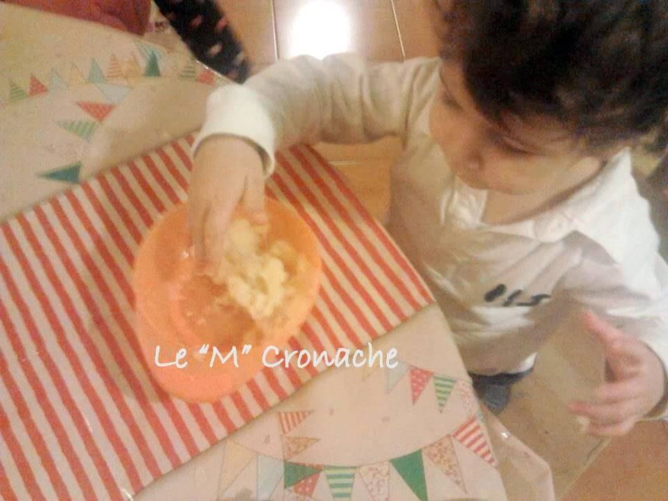 Le mani del bambino eseguono sbucciare le patate usando un pelapatate.  attrezzatura speciale per le verdure cotte.